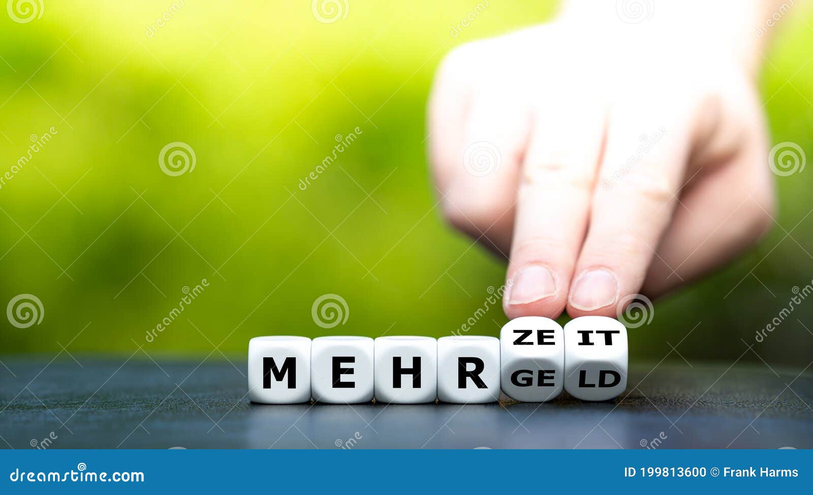hand turns dice and changes the german expression `mehr geld` more money to `mehr zeit` more time.