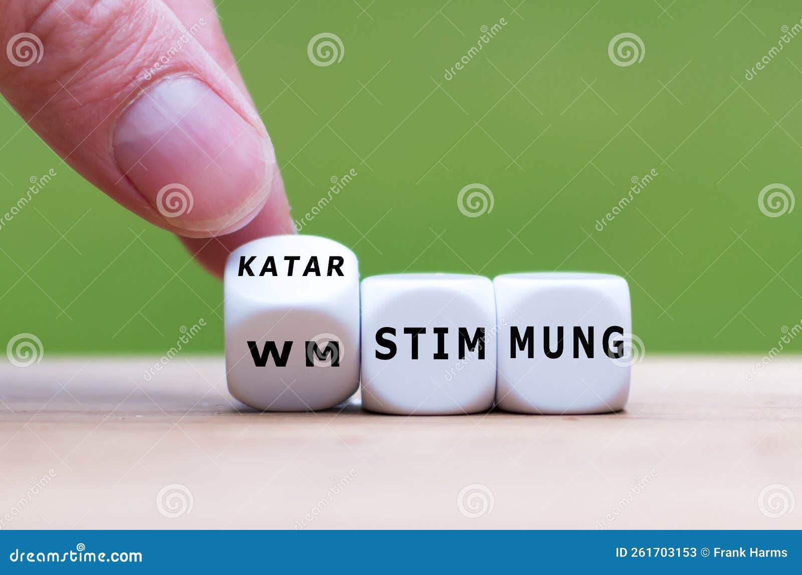 hand turns dice and changes the german expression `wm stimmung` world cup atmosphere to `katar stimmung` qatar atmosphere.