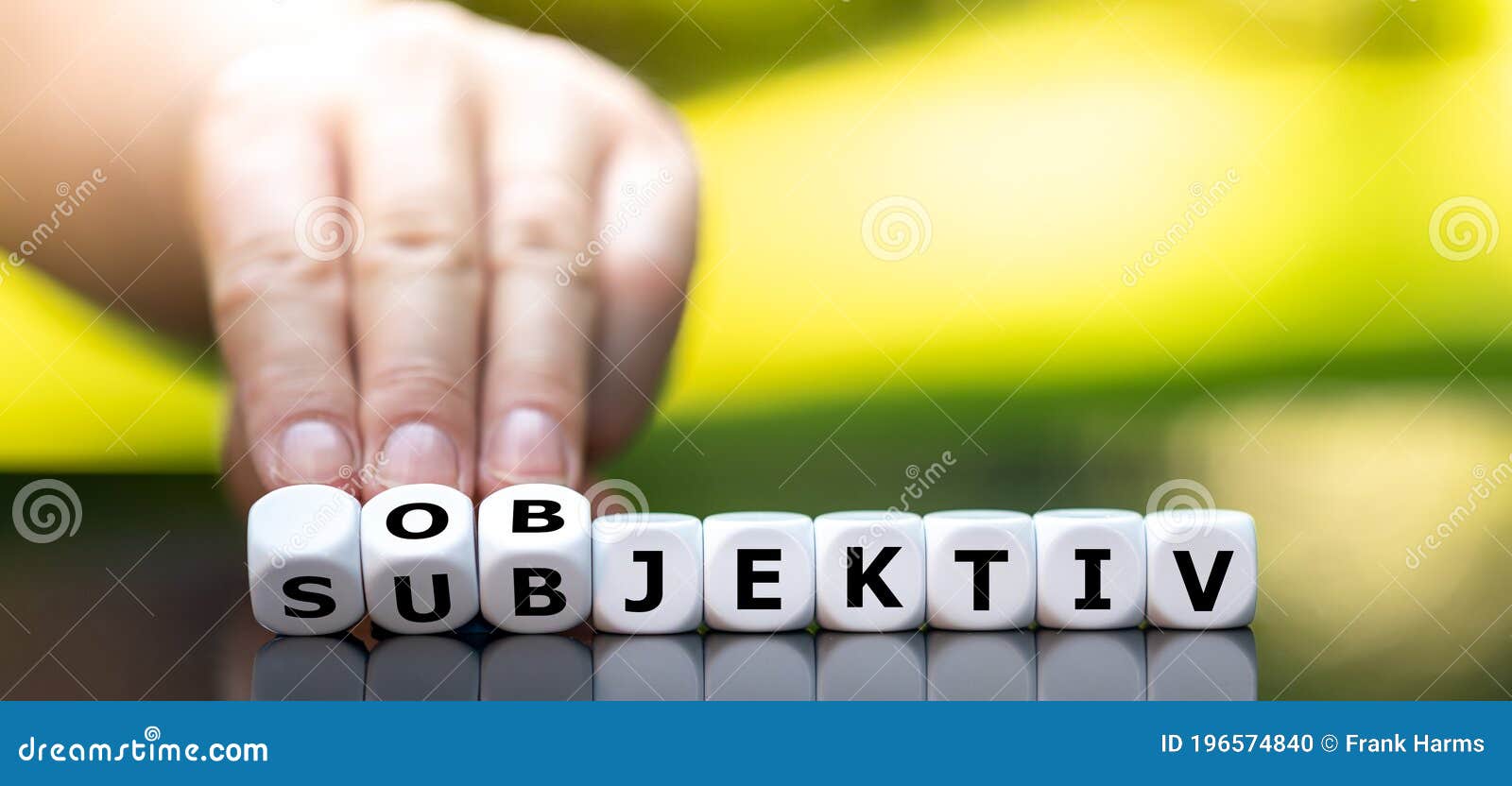 hand turns dice and changes the german word `subjektiv` subjective to `objektiv` objective.