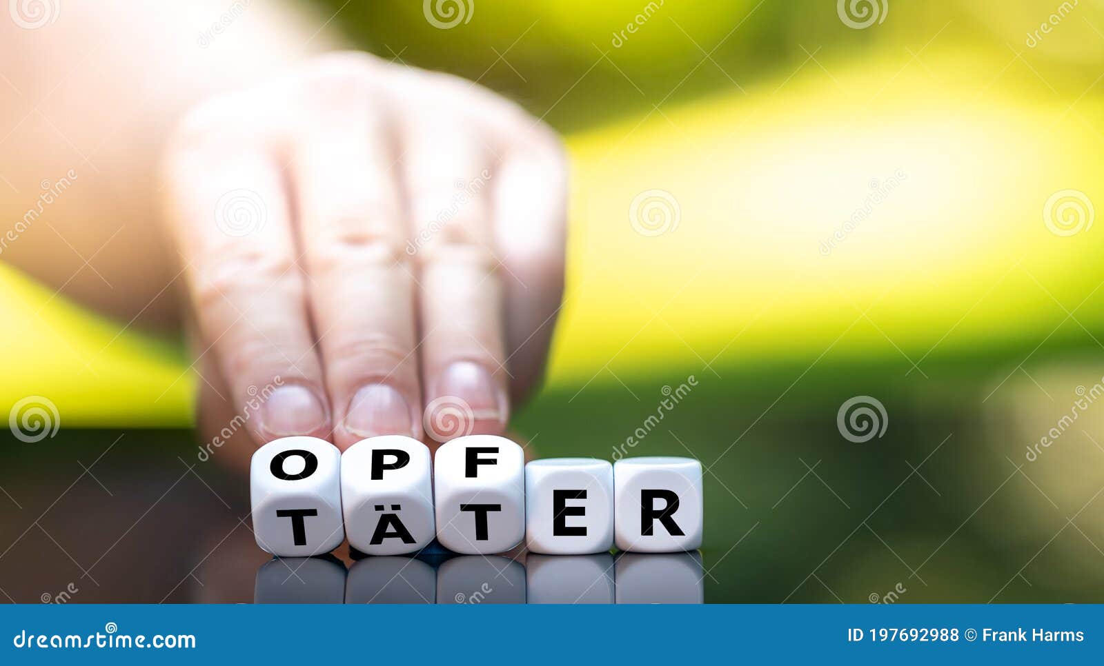 hand turns dice and changes the german word `taeter` offender to `opfer` victim.