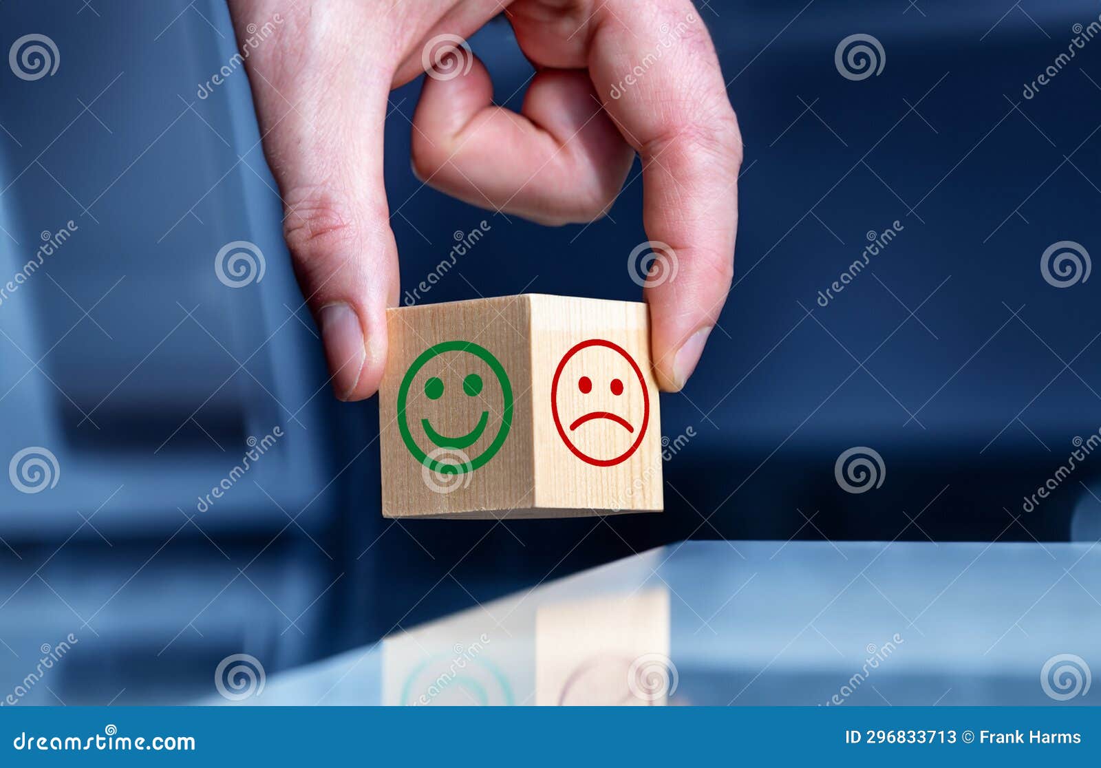 hand turns wooden cube and changes the expression of a smily.