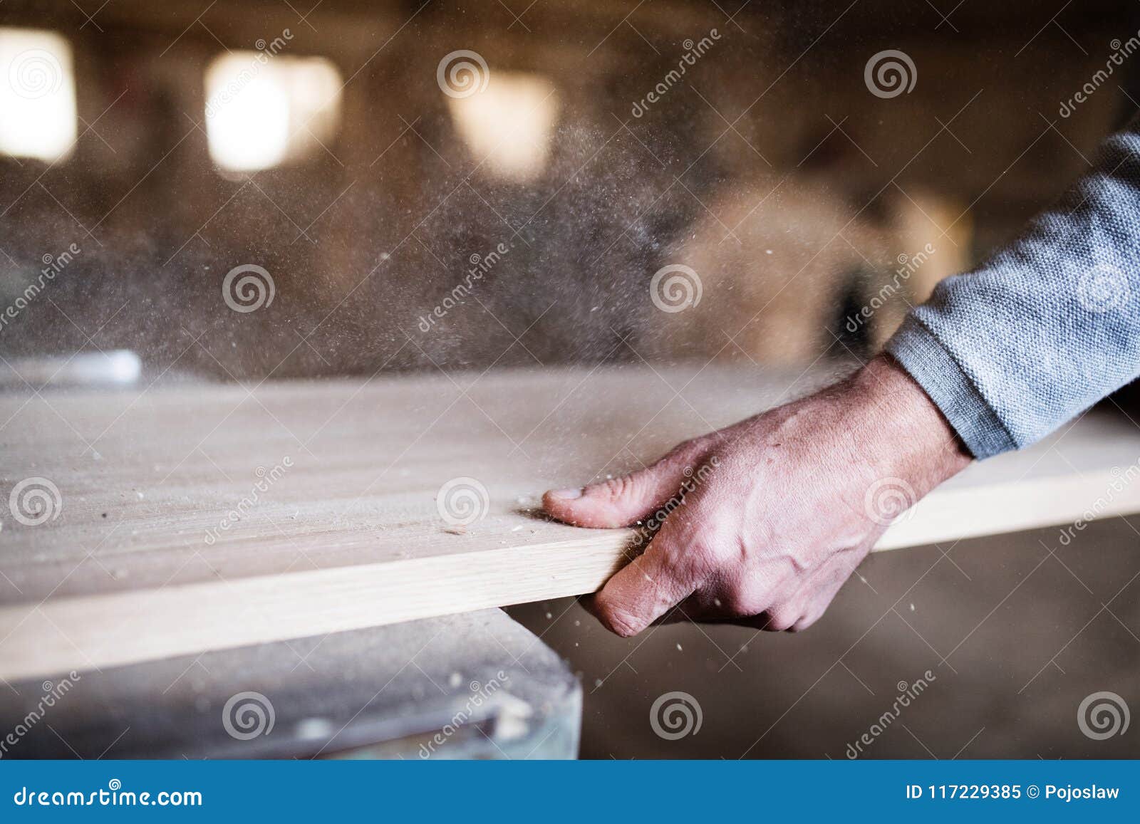an unrecognizable man worker in the carpentry workshop, working with wood.