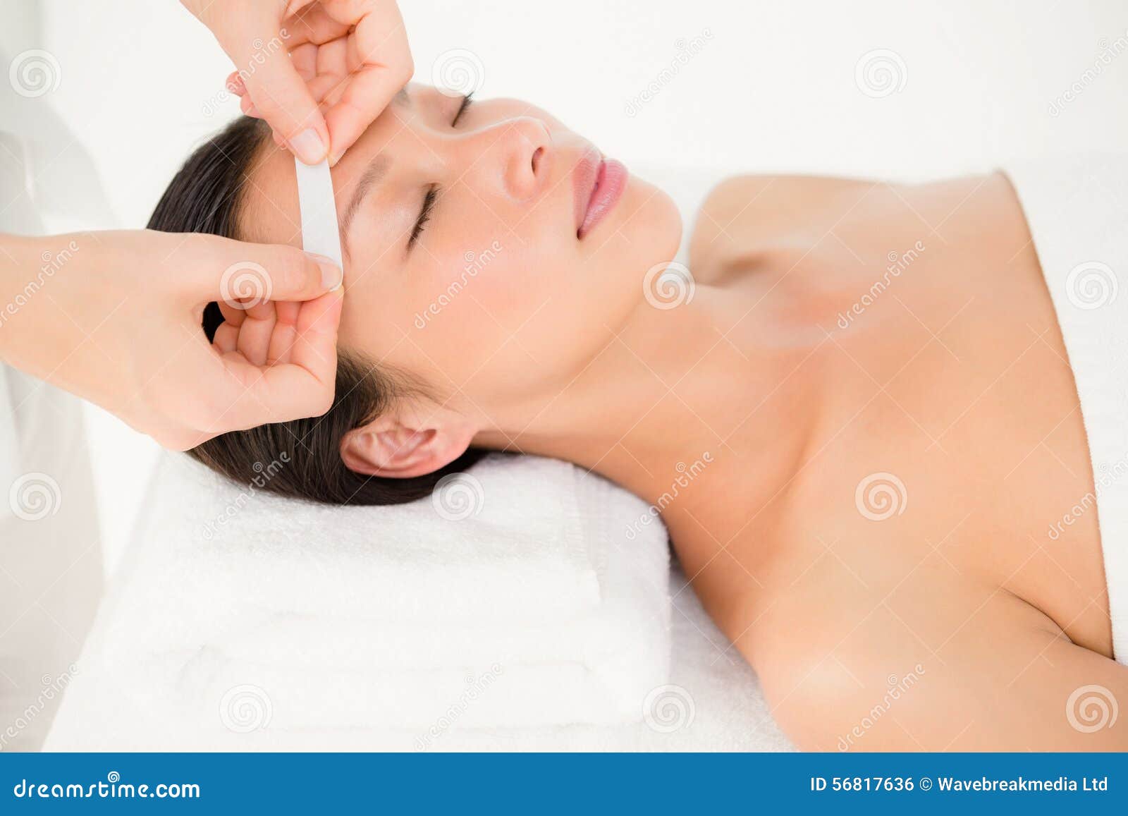 hand waxing beautiful womans eyebrow