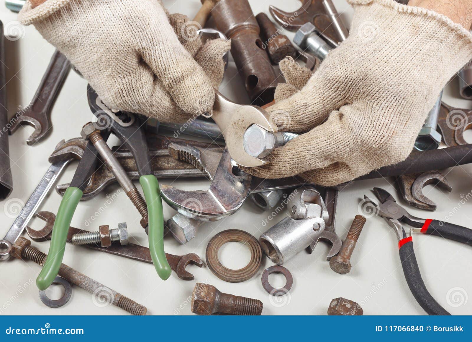Hand of Worker in Gloves with Wrench To Tighten the Nut Stock Photo