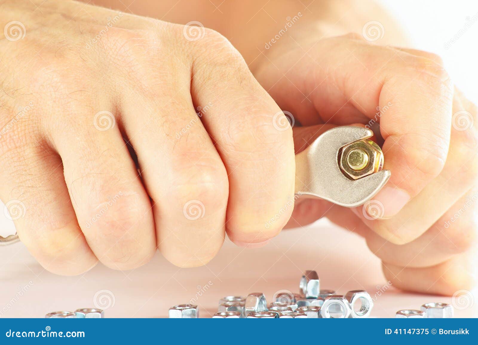 Hand of Worker with a Spanner To Tighten the Nut Closeup Stock Image