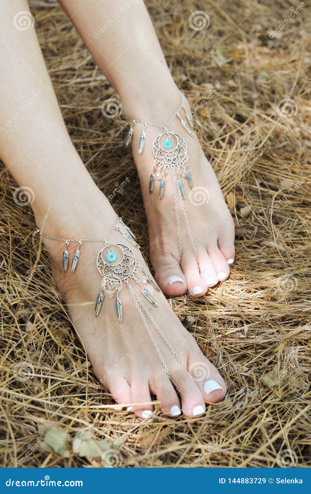 handcrafted bracelets on a woman legs, close up, white pedicure