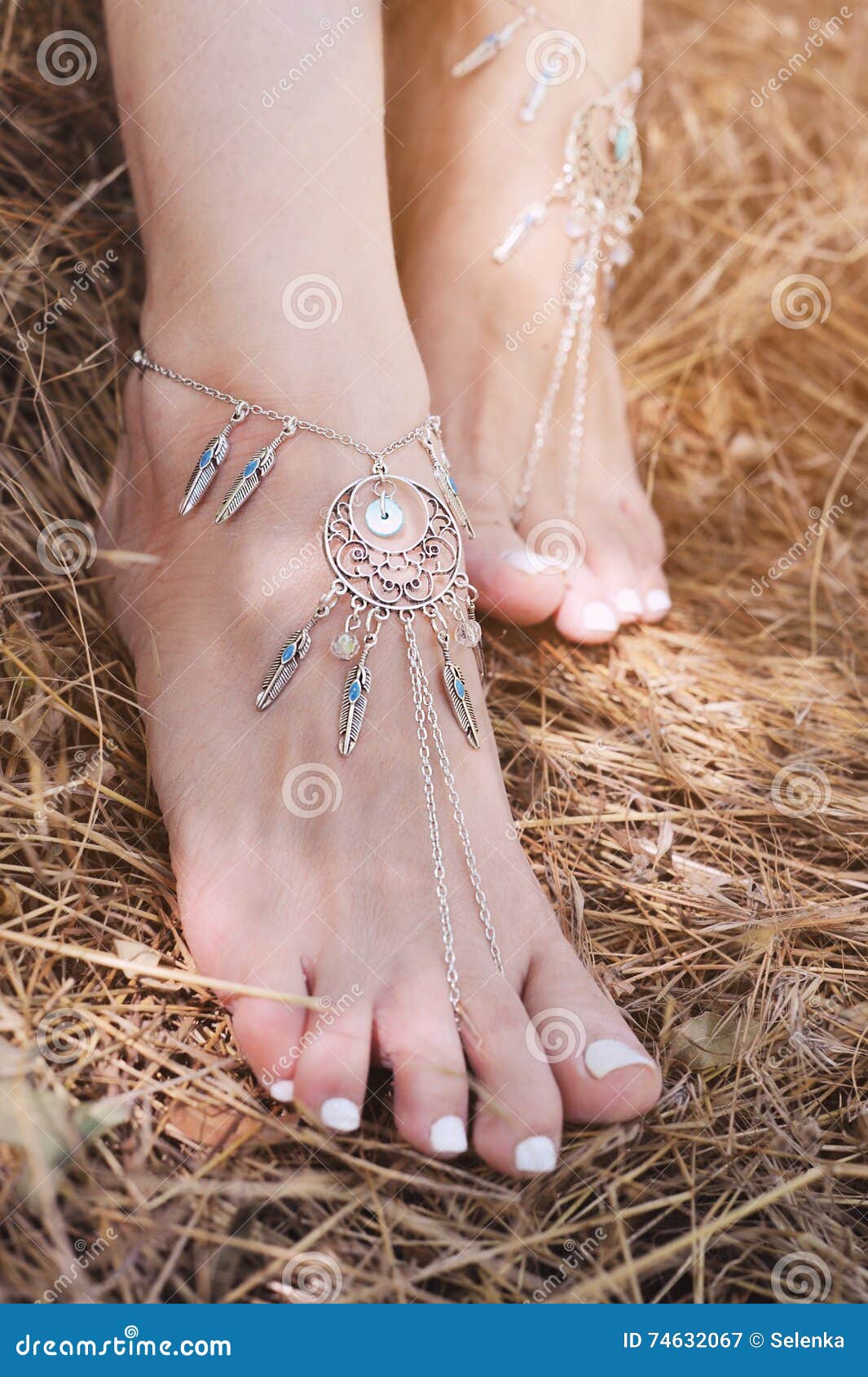 handcrafted bracelets on a woman legs, close up, white pedicure