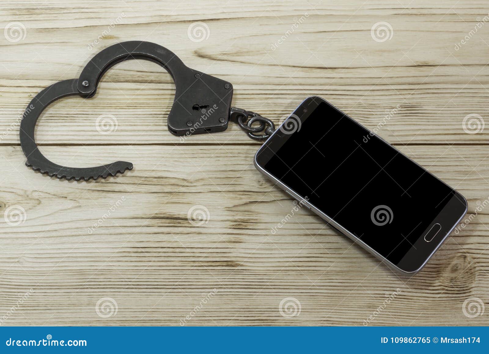 Download Handcuffs And Telephone On The Background Of A Wooden ...