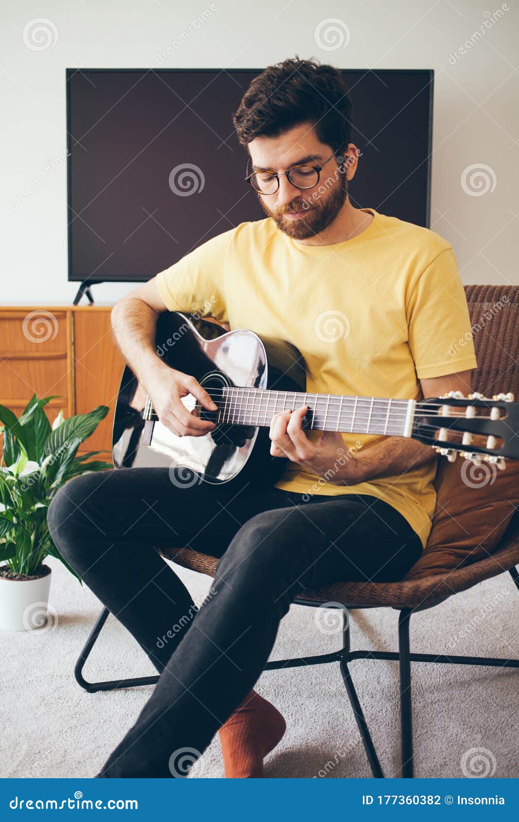 Hoofdkwartier werkplaats Corroderen Handige Beard Man Neemt Online Gitaarcursus. Man in Een Geel Shirt Speelt  Thuis Een Akoestische Gitaar Met Een Mooie Stock Foto - Image of  toepassing, glazen: 177360382