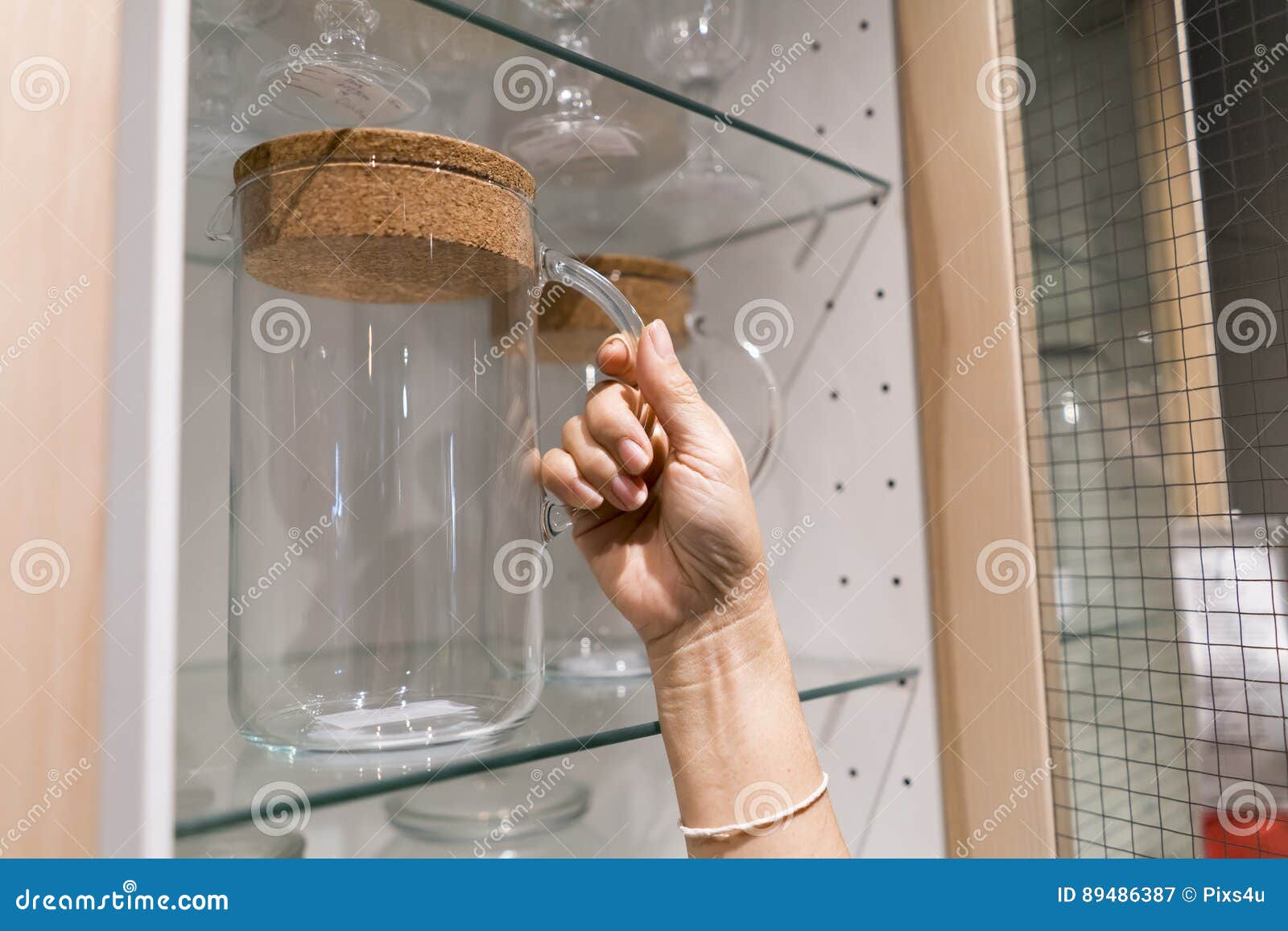 Handling A Big Glass Jar Packing Of Food In The Display Cabinet