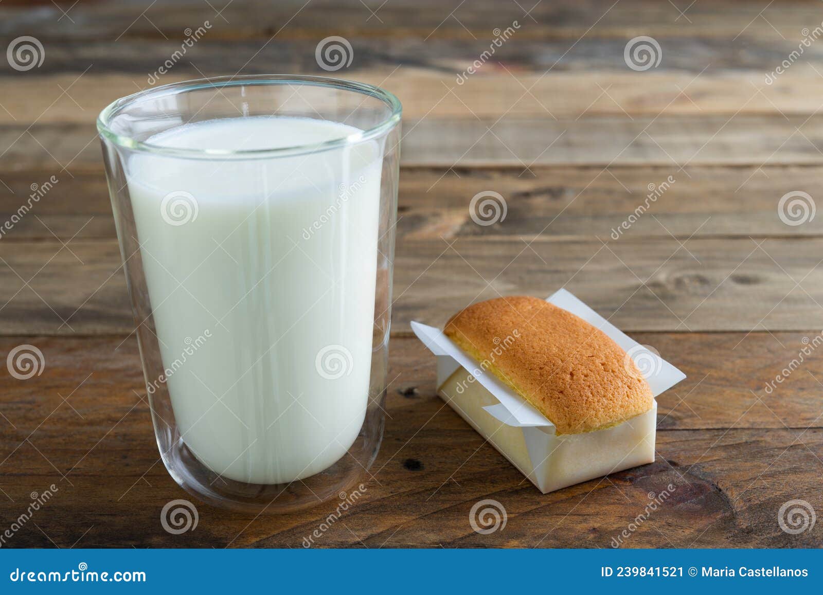 handmade cupcake and glass of milk on a wooden background. copy space. handmade traditional spanish