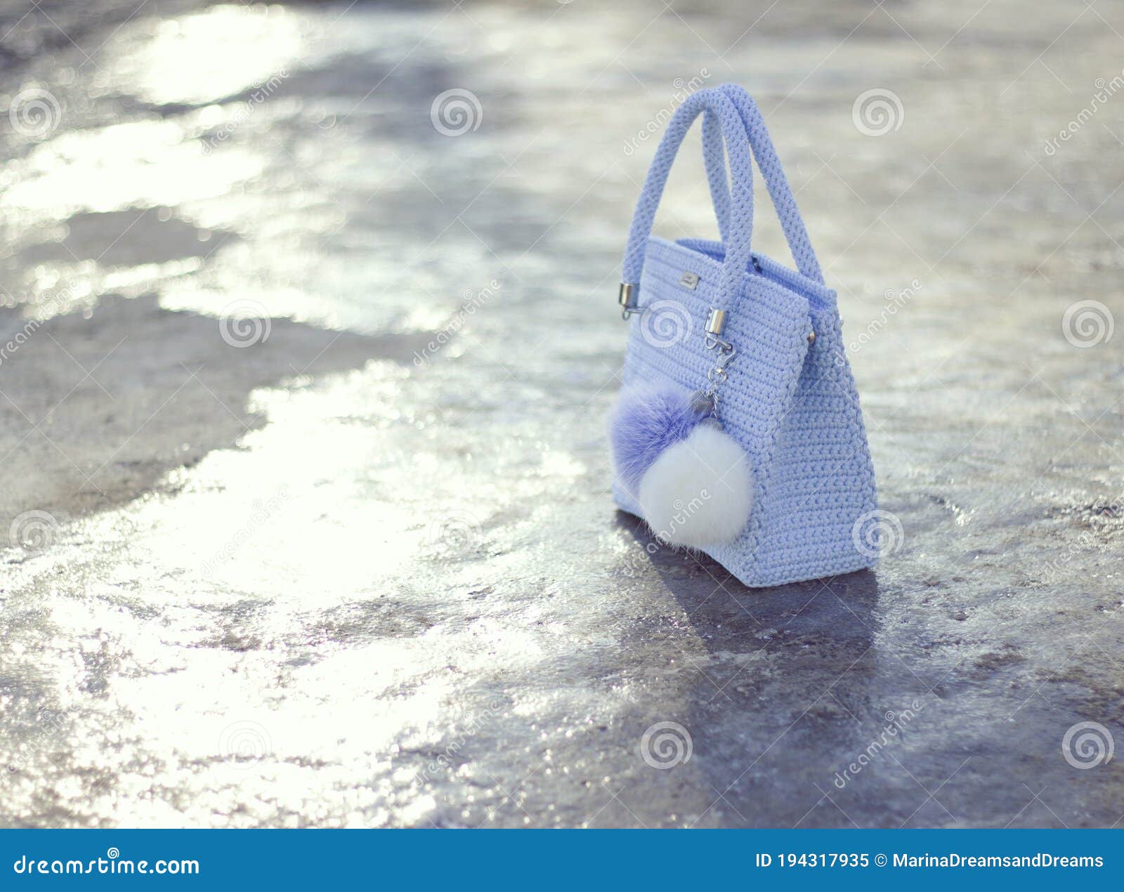 handmade light blue textile knitted bag with pompons