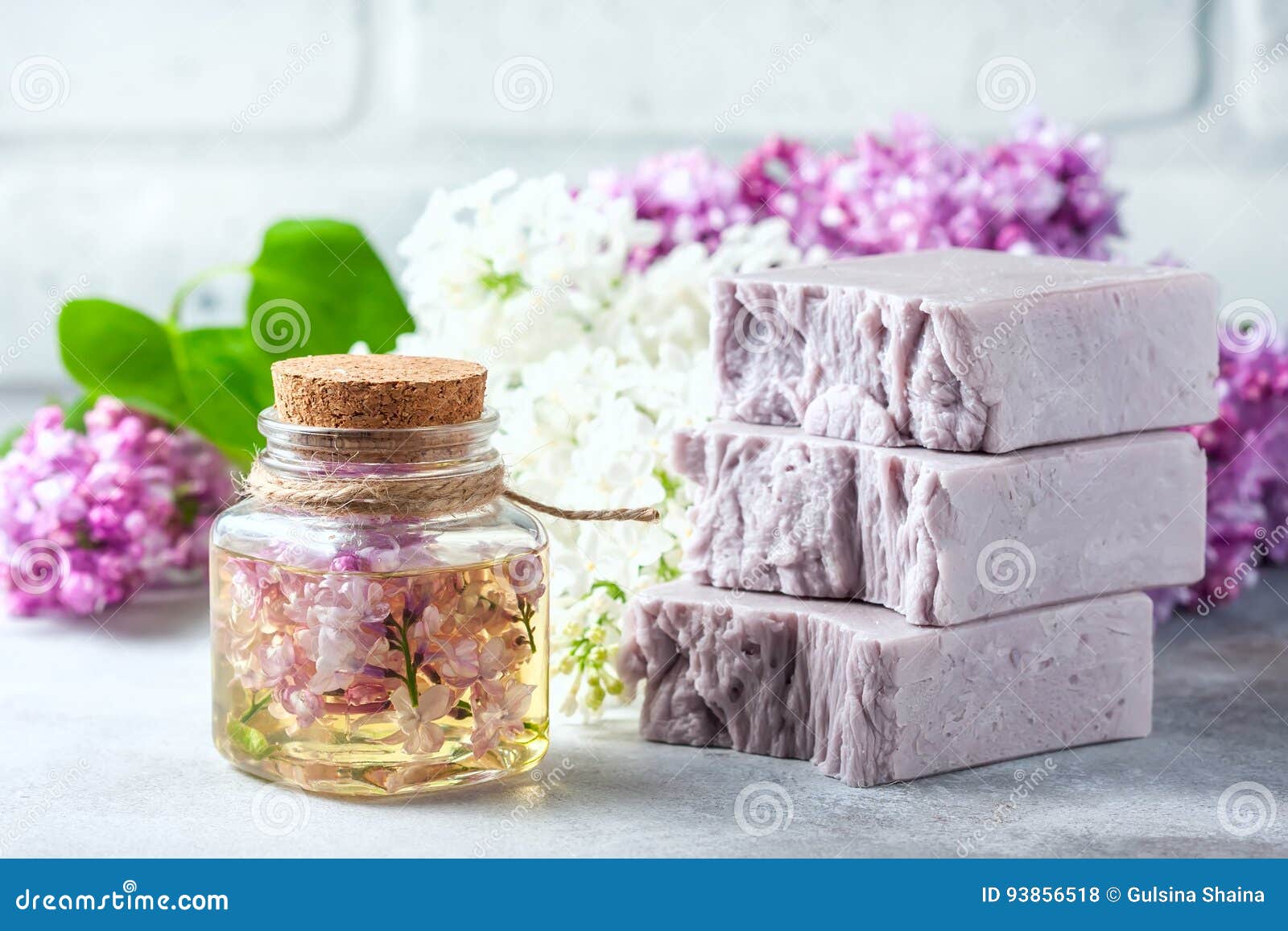 handmade soap, glass jar with fragrant oil and lilac flowers for spa and aromatherapy.