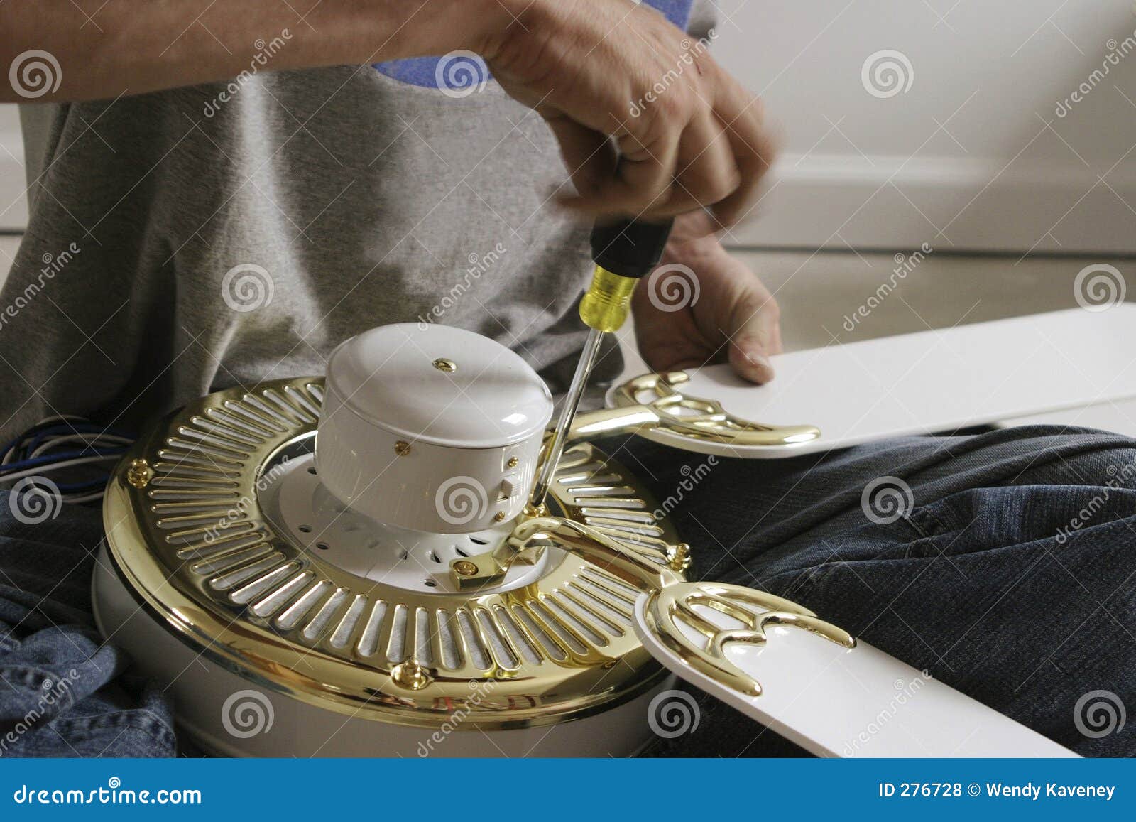 hands assembling a ceiling fan