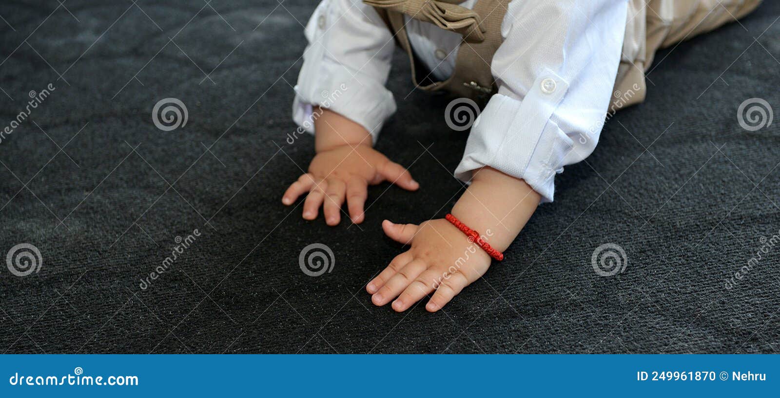 Hands of a Baby Boy while Crawling on a Black Carpet Stock Photo