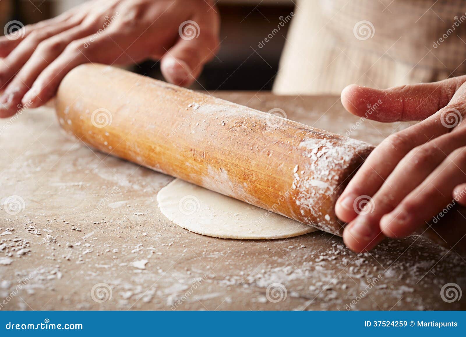 hands baking dough with rolling pin
