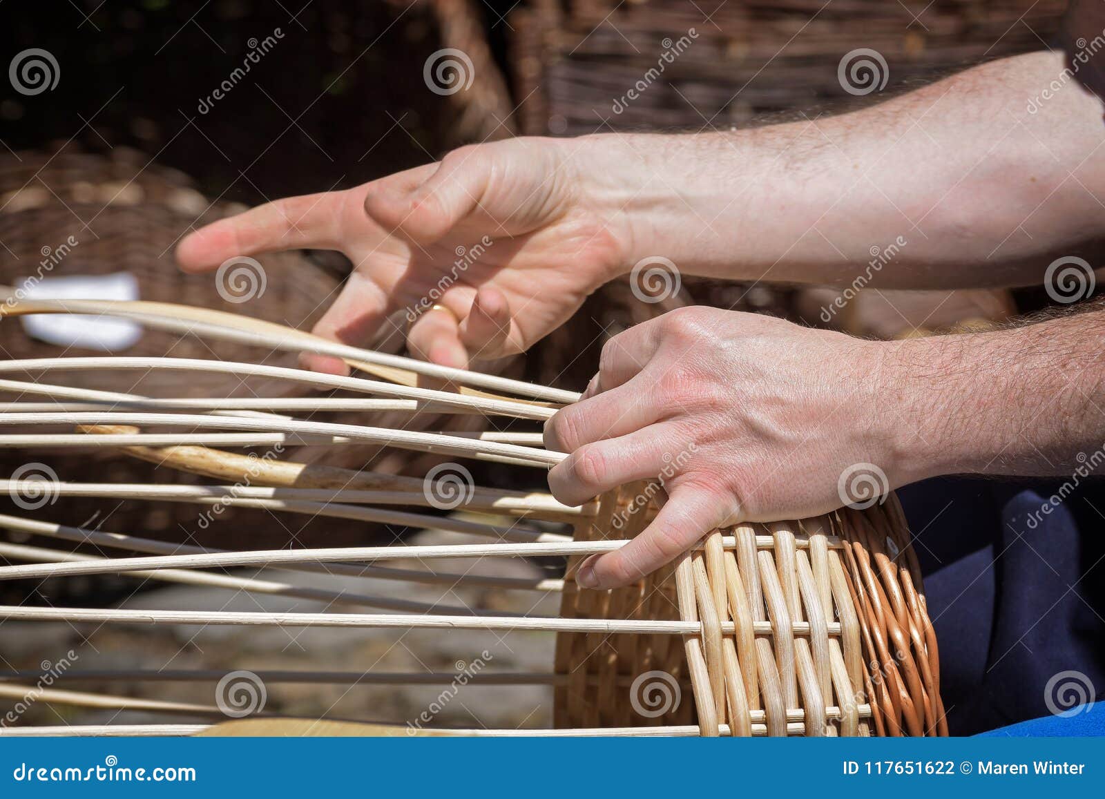 Hands of a Basket Maker are Braiding a Wicker Basket Stock Photo