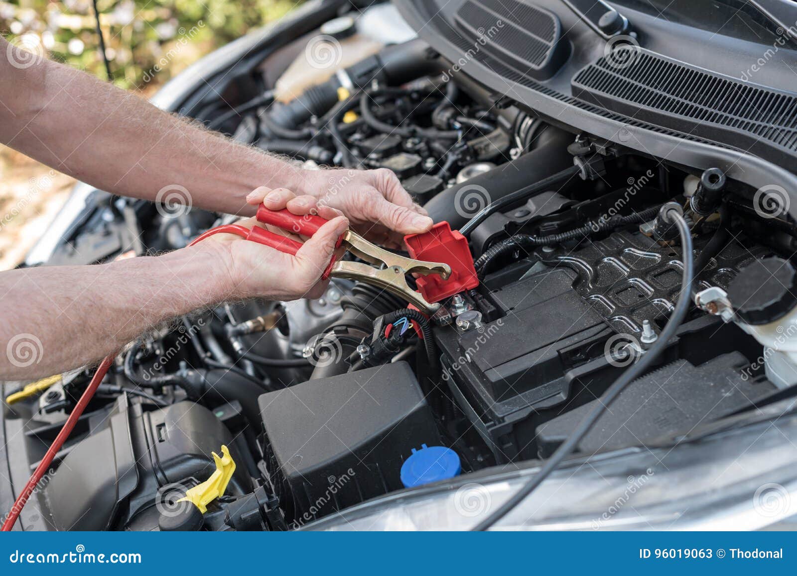Hands of Car Mechanic Using Car Battery Jumper Cable Stock Image