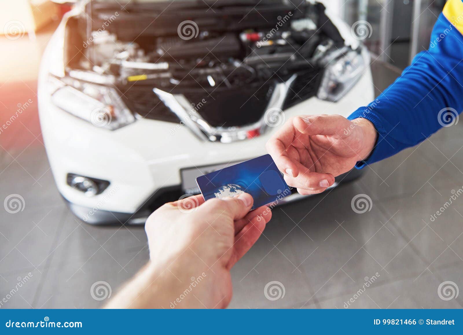 Hands of Car Mechanic with Wrench in Garage, Payment by Credit Card