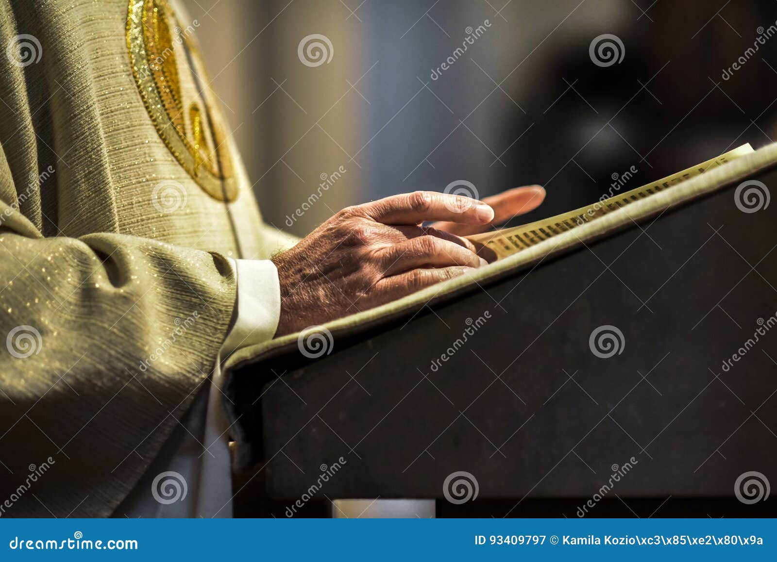 hands of catholic priest reading a bible.