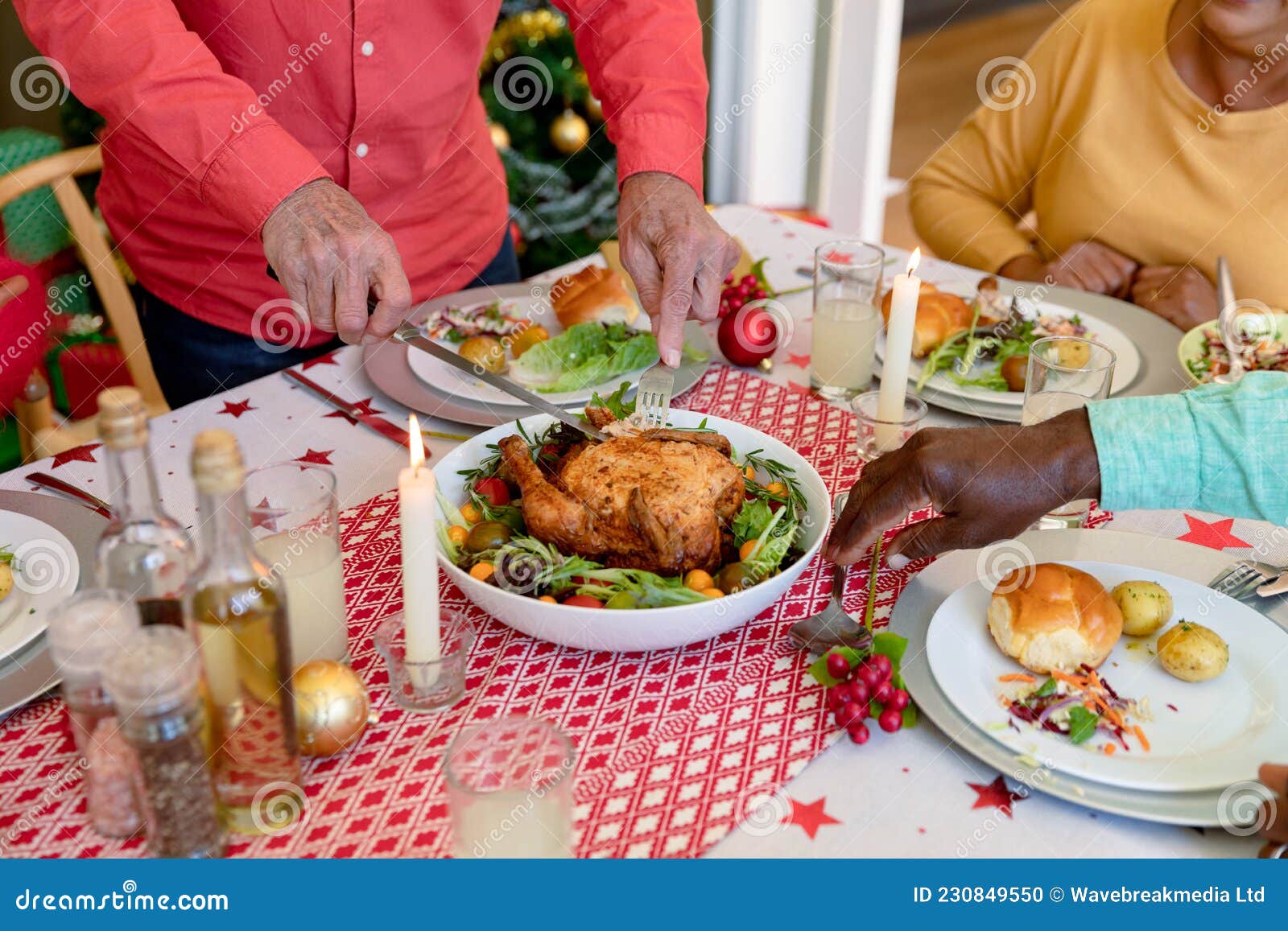 hands of cauasian senior man cutting chicken at christmas table
