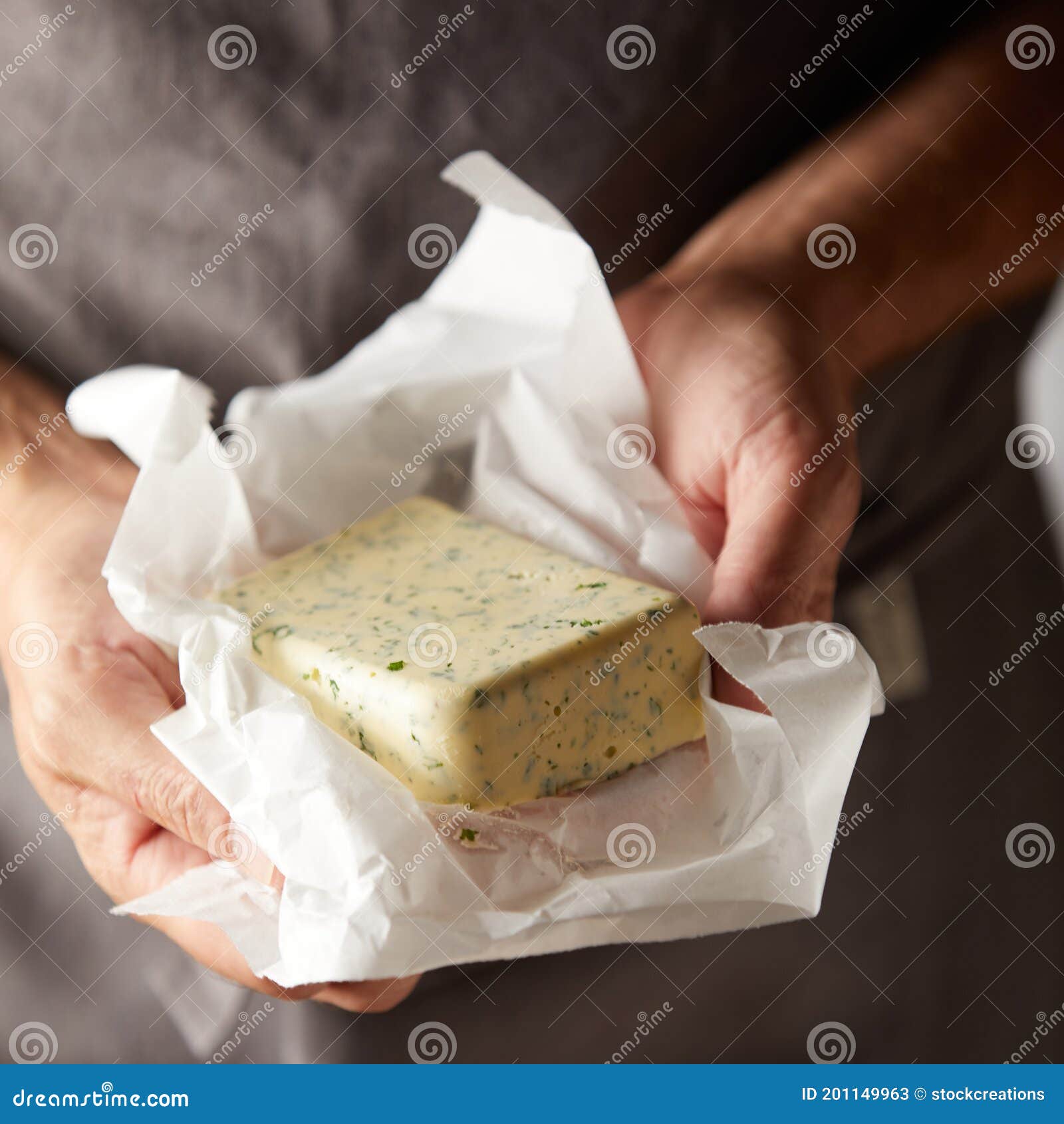 hands of a chef holding a pat of herb butter
