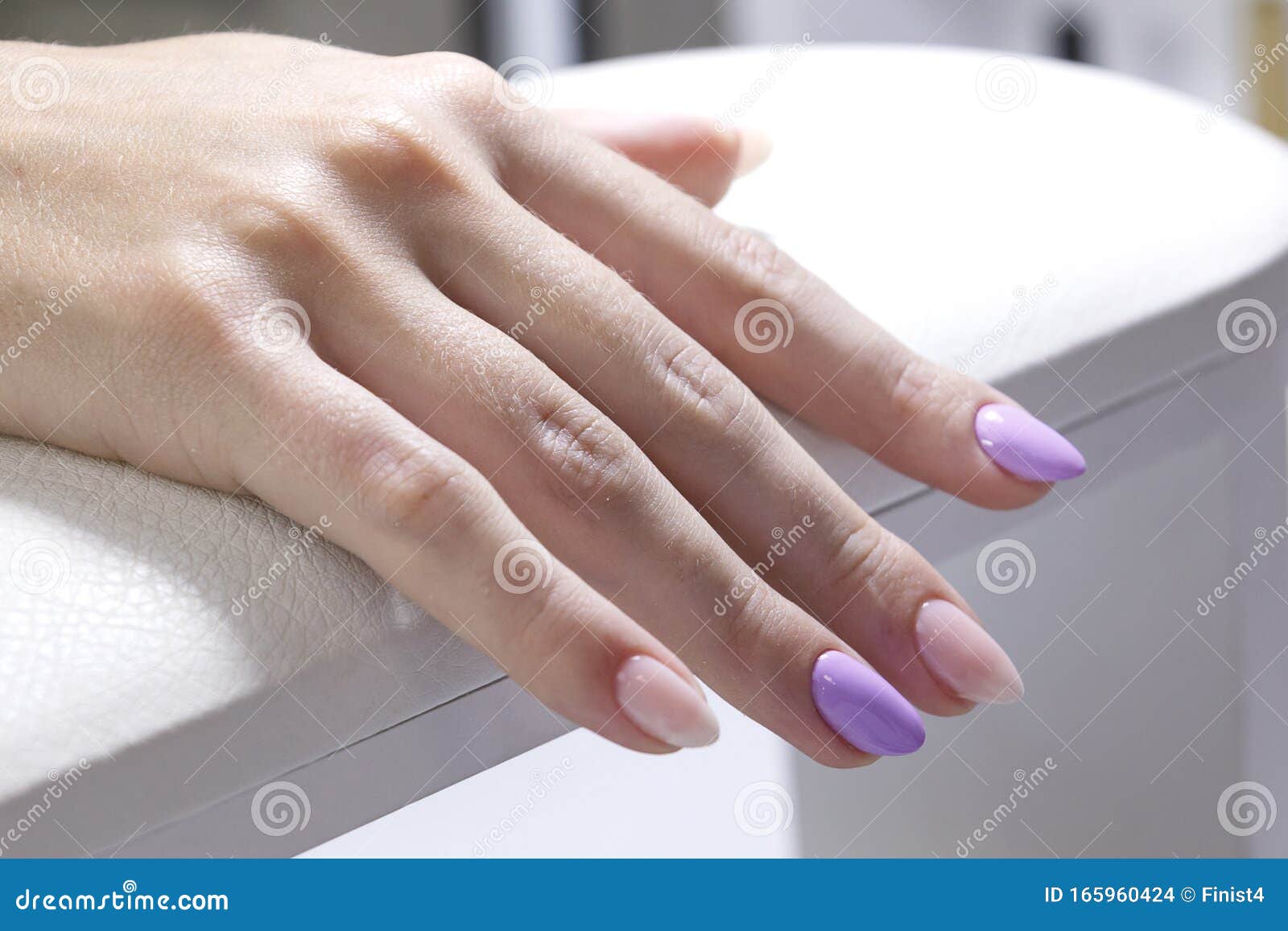 hands of a client with colored gel coated nails closeup.