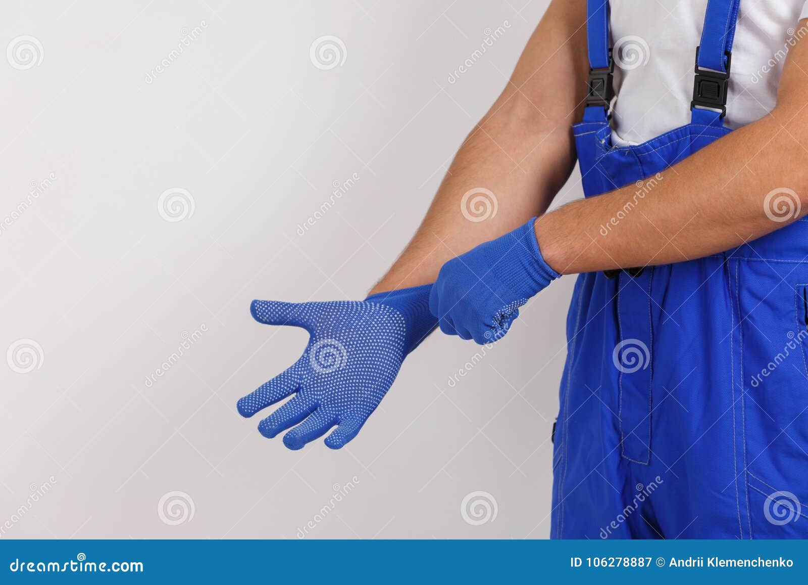 The Male Hands of a Worker in Uniform, Wearing Construction Gloves ...