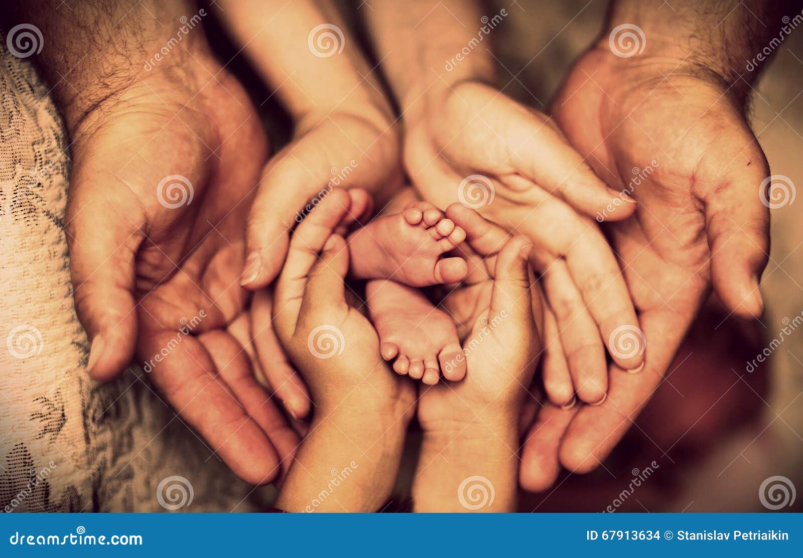 hands of father, mother, daughter keep little feet baby. friendly happy family