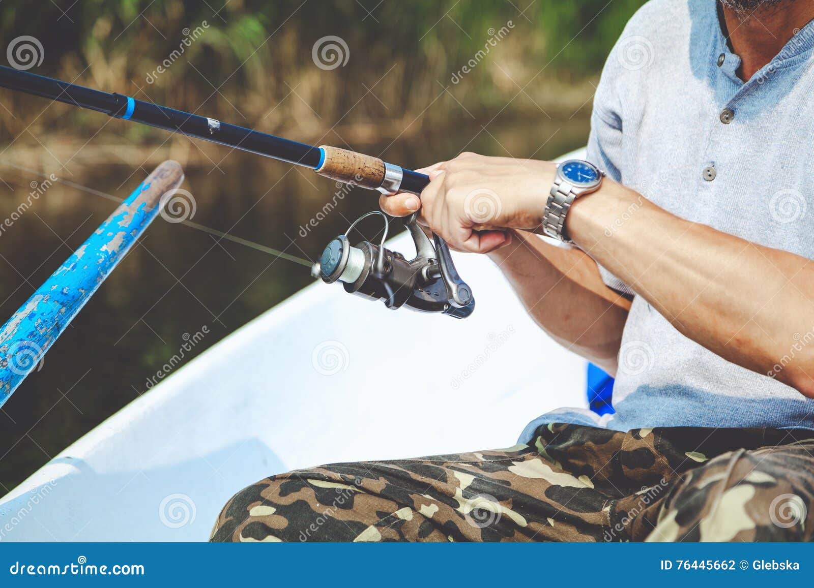Hands Fisherman Holding Fishing Rod and Reel Handle is Rotated Stock Photo  - Image of nature, recreation: 76445662