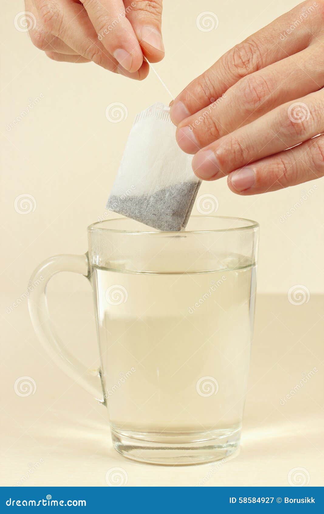Hands are Going To Brew a Tea Bag in Cup of Boiling Water Stock Image