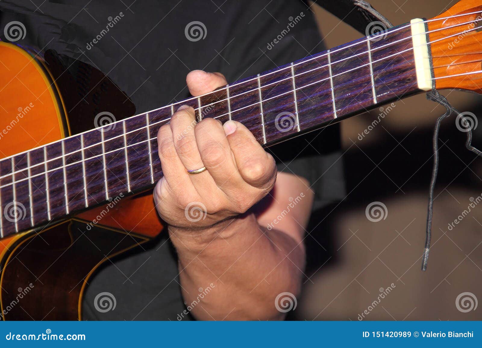 the hands of the guitarist make the strings of the instrument vibrate