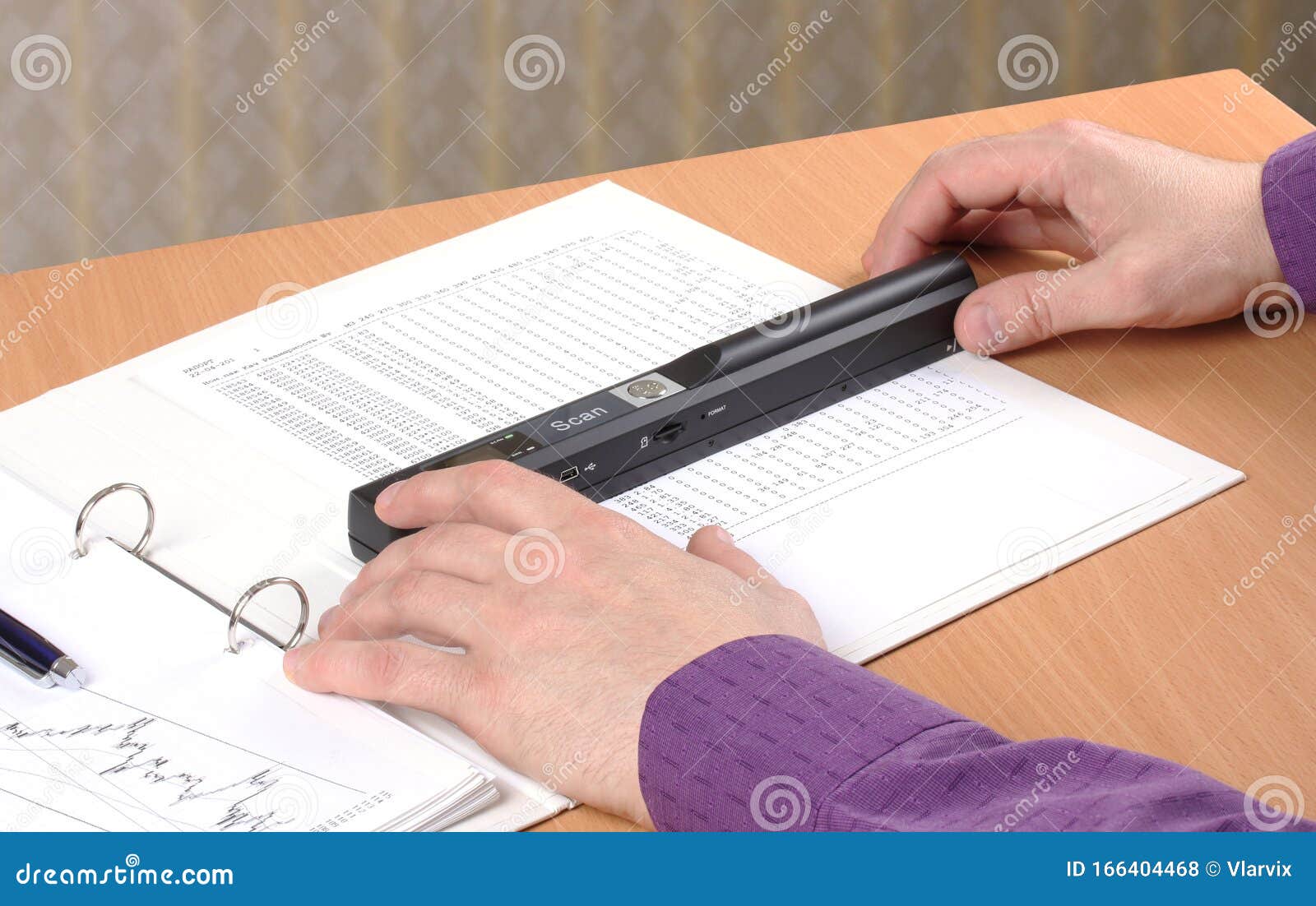 Hands Hold a Handheld Portable Scanner and Move it on a Sheet of Paper