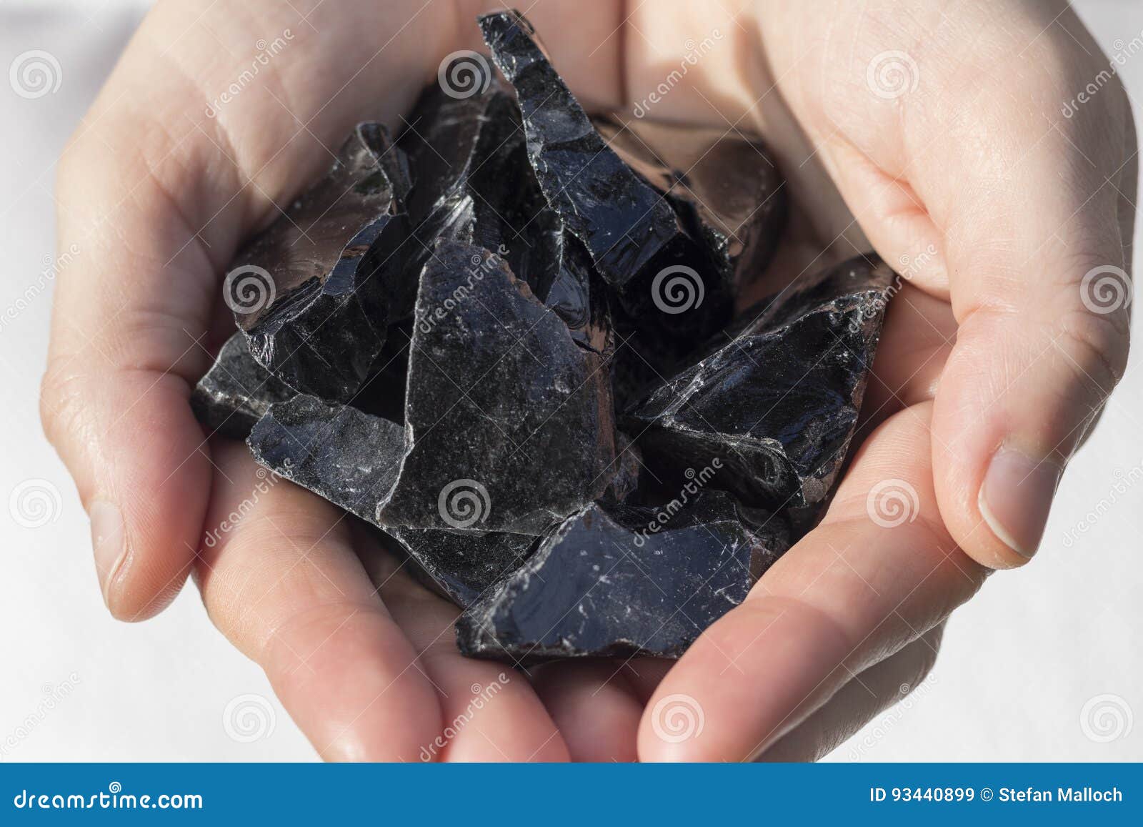 hands holding black obsidian