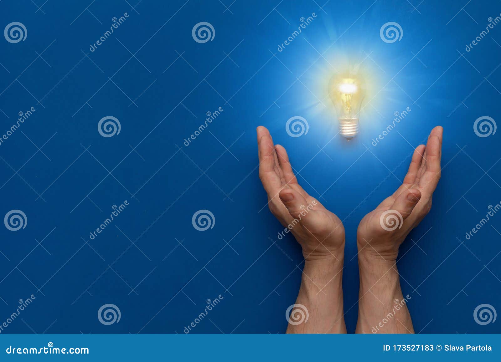 Hands Holding A Burning Light Bulb On A Blue Stock Image ...