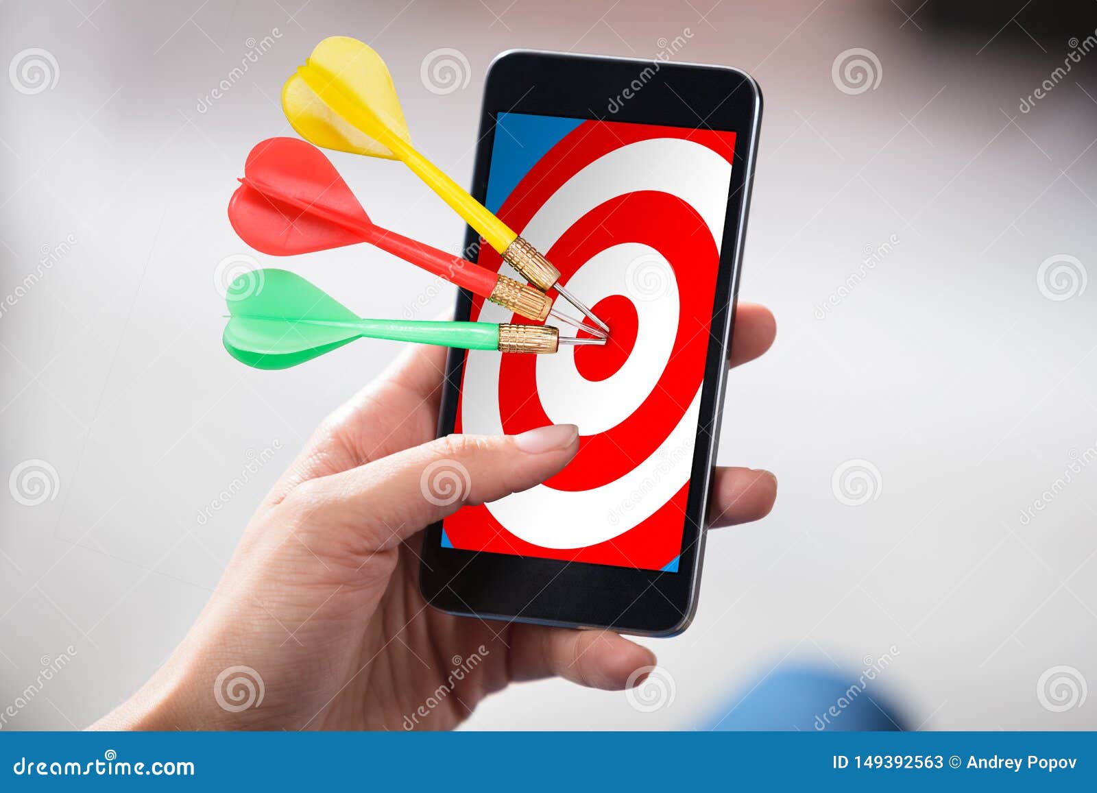 person holding cellphone with darts on target