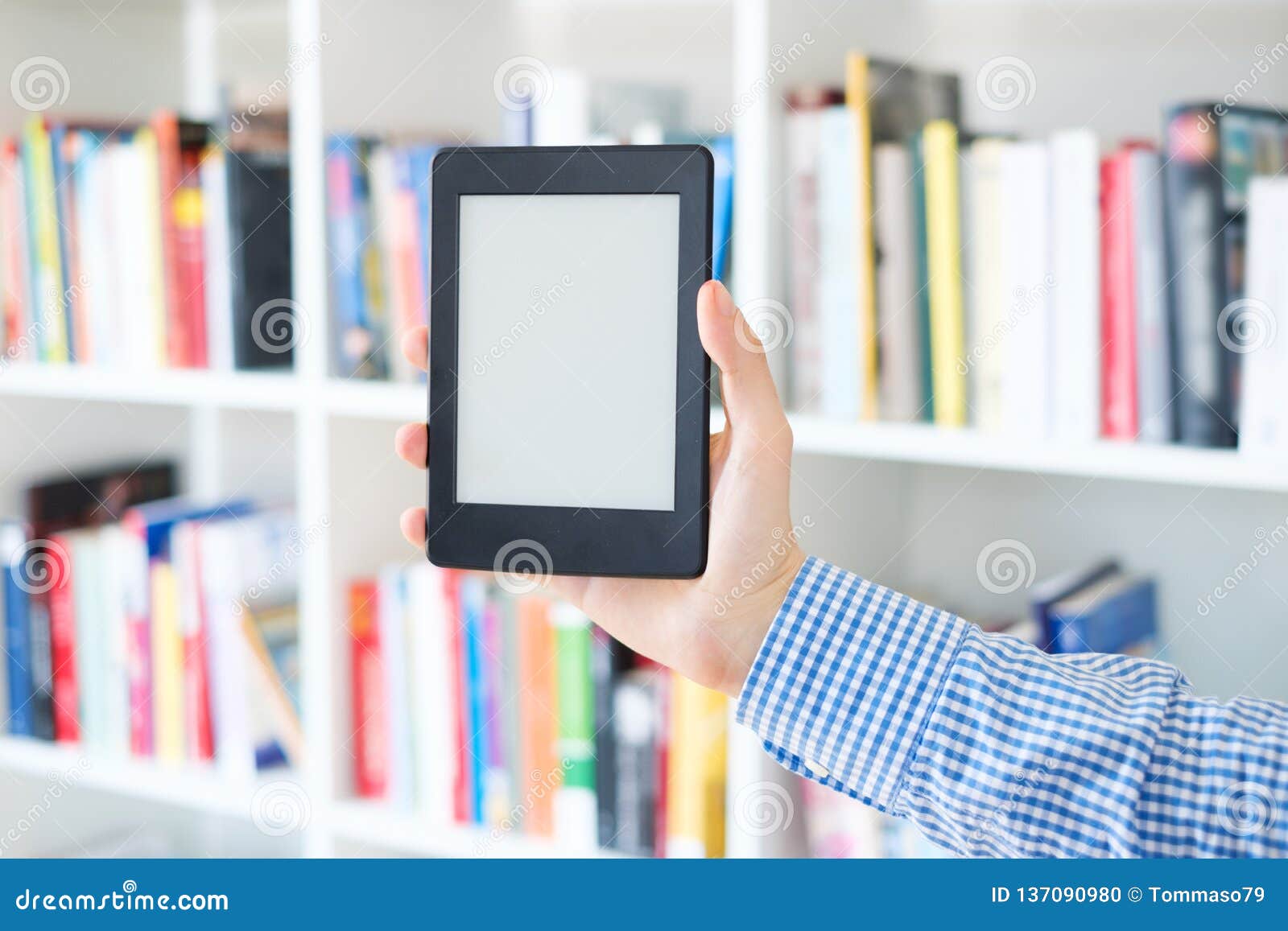 Hands Holding Ebook on Bookshelf Background.Copy Space on Digital