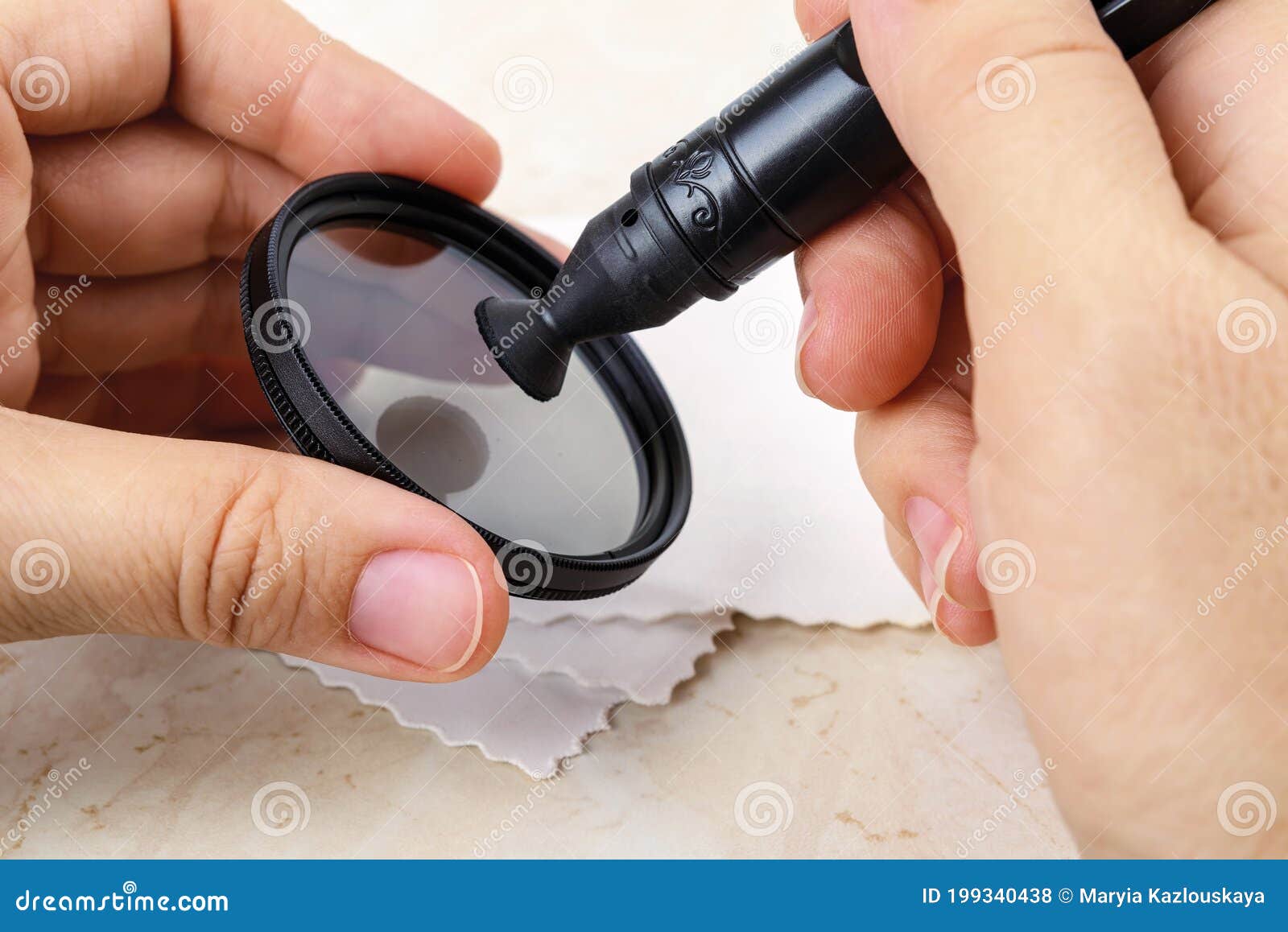Hands Holding a Lens Pen and Cleaning a Camera Polarizing Filter with