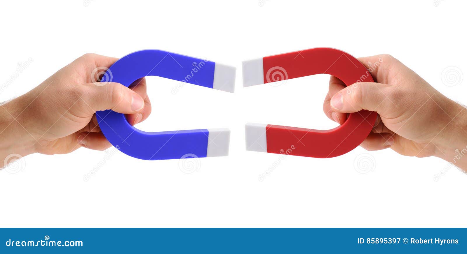 hands holding magnets one red and one blue