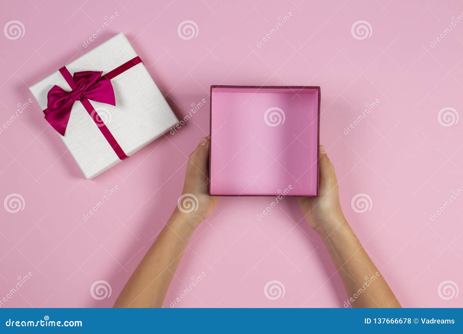 Hands Holding Open Empty Present Gift Box on Pastel Pink Background