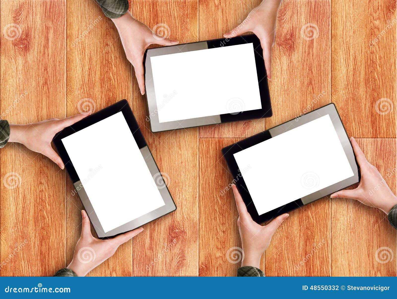 hands holding three digital tablet computers