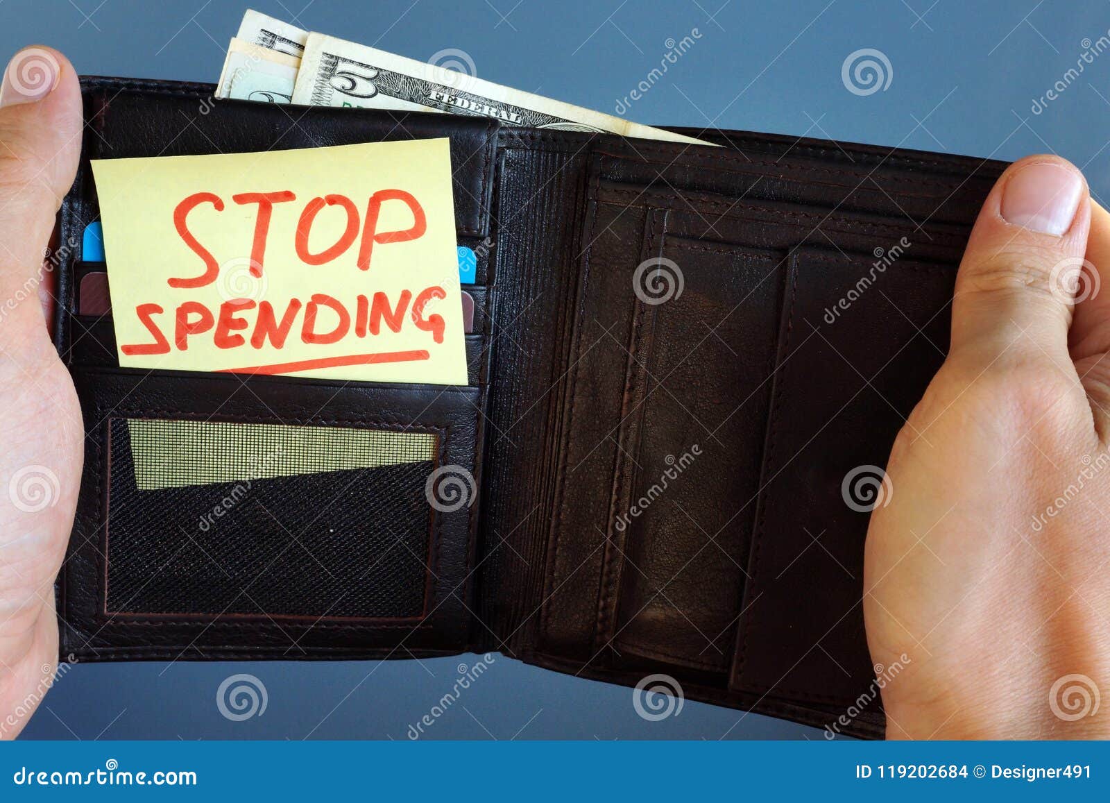 hands holding wallet with stick stop spending.