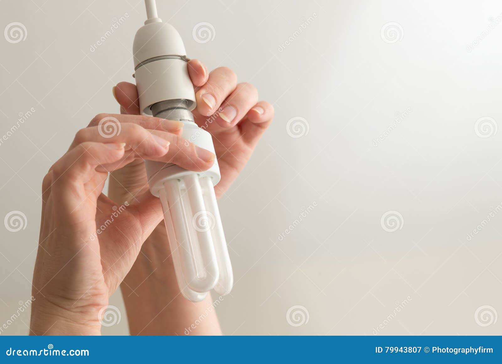 hands install or remove energy saver light bulb copy space