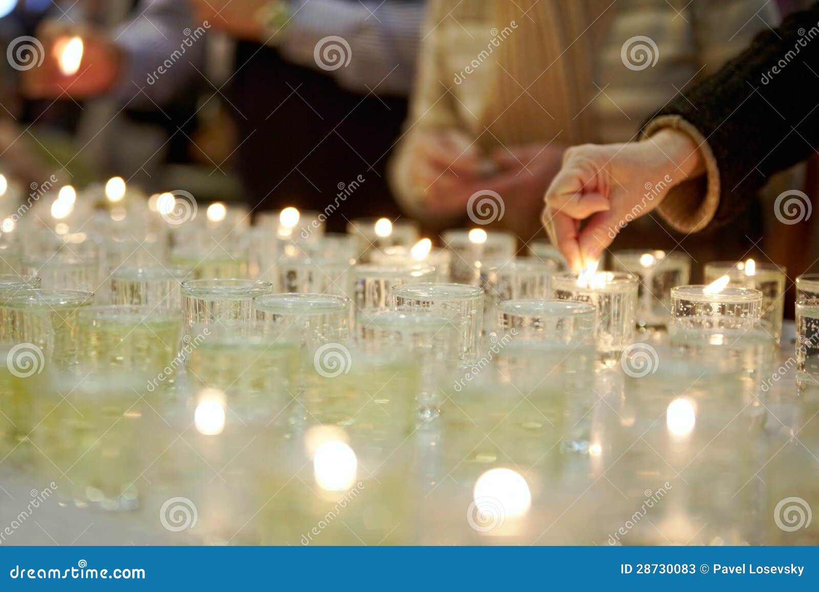hands lighting funeral candles