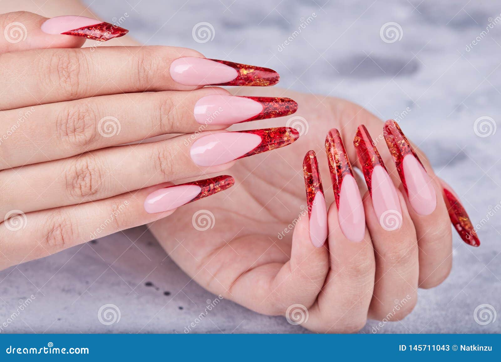 hands with long red artificial french manicured nails