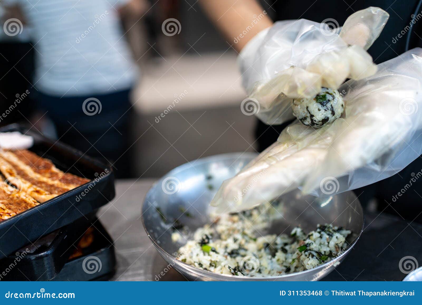 hands making korean seaweed rice ball called in korean is jumeogbab, jumeokbap, onigiri or chu mok bab is famous traditional