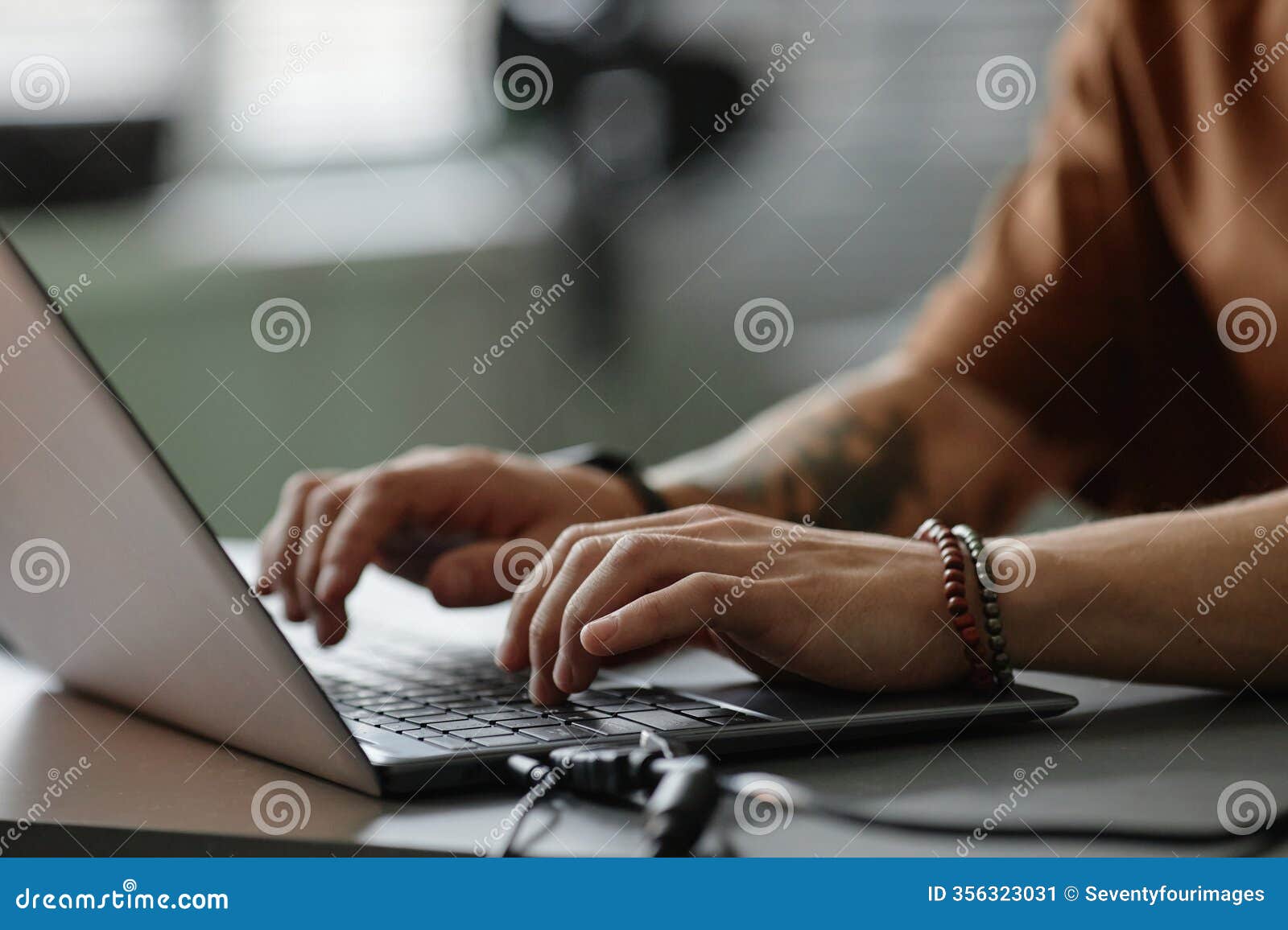 hands of male programmer typing on laptop keyboard working in office