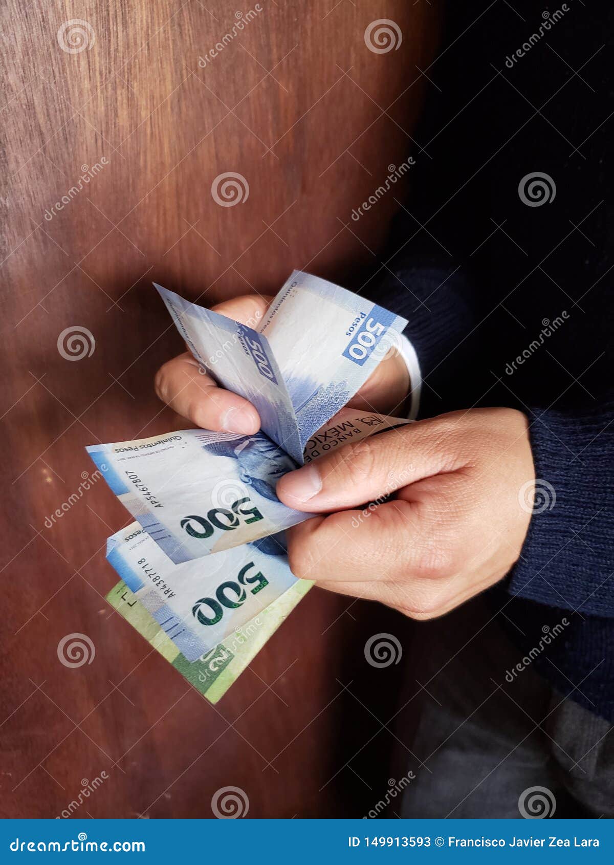 hands of a man counting mexican banknotes