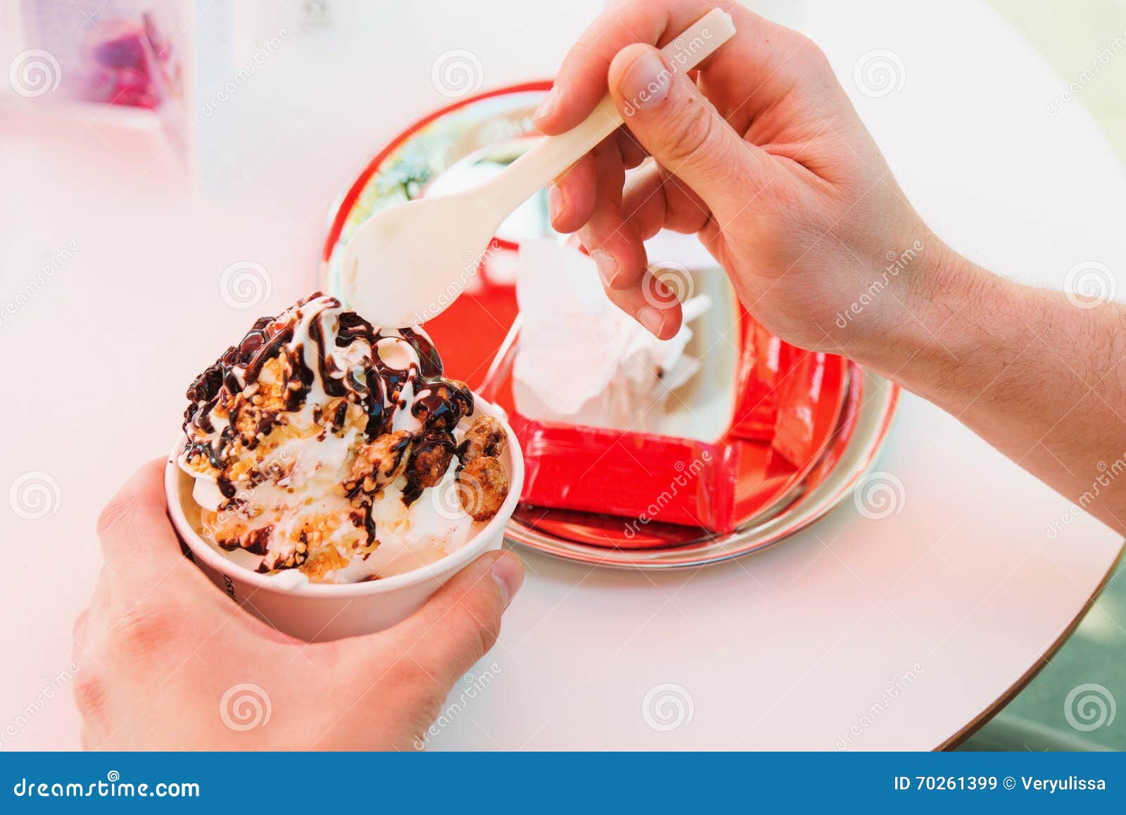 Hands of Man Eating Frozen Yogurt at Cafe Table. Horizontal Shot Stock