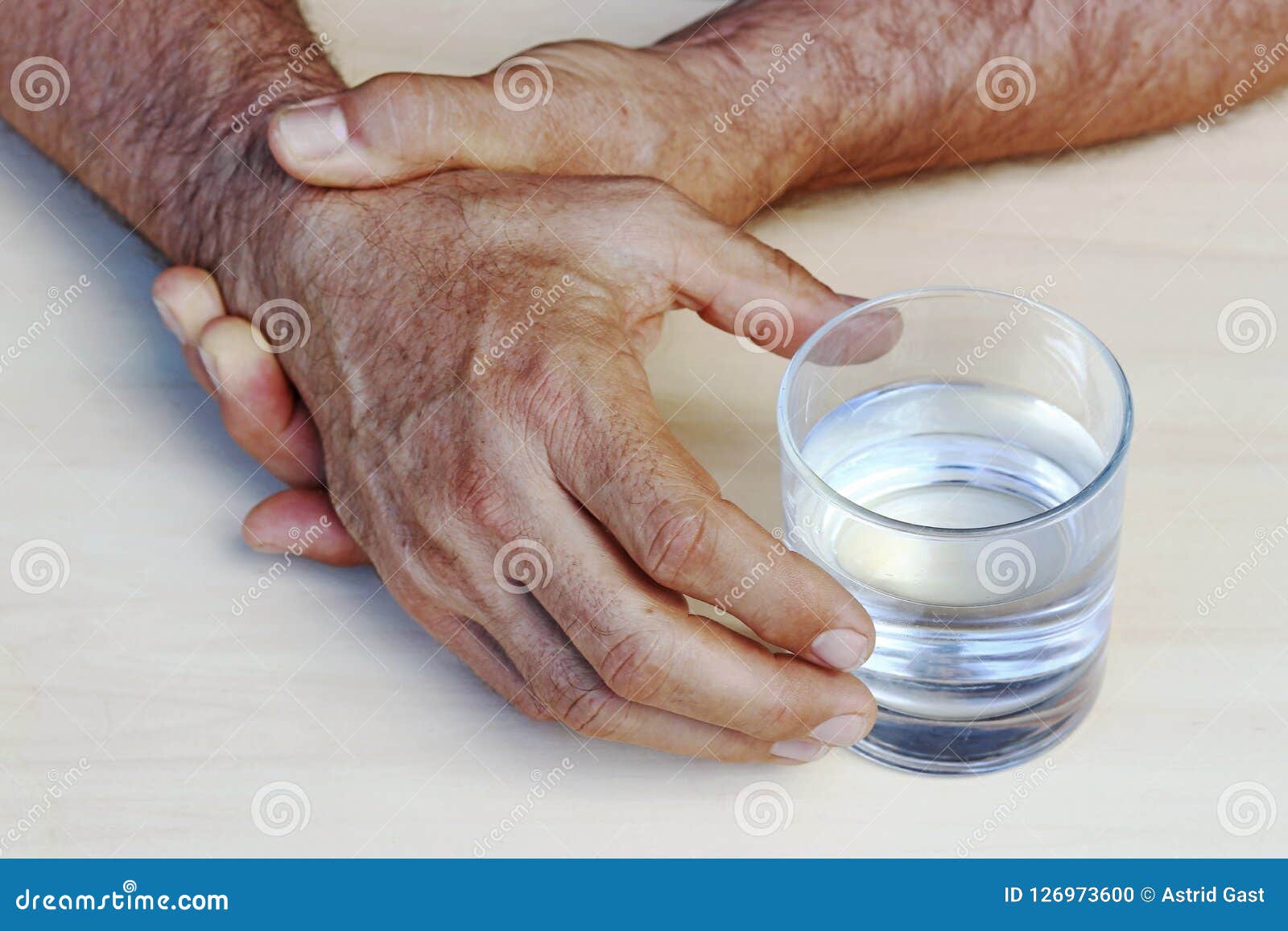 the hands of a man with parkinson`s disease tremble